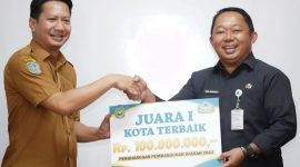 Kepala Bappeda Maluku Utara Muhammd Sarmin S. Adam Berikan Penghargaan dalam Bentuk Uang kepada Kepala Bappelitbangda Kota Ternate Rizal Marsaoly. (Ko Edo for Rakyatmu)