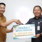 Kepala Bappeda Maluku Utara Muhammd Sarmin S. Adam Berikan Penghargaan dalam Bentuk Uang kepada Kepala Bappelitbangda Kota Ternate Rizal Marsaoly. (Ko Edo for Rakyatmu)