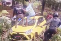 Tangkapan Layar Warga Memukul Kaca Depan Mobil yang Dikendarai AT Menggunakan Helem di Lingkungan Facei. (Rakyatmu)
