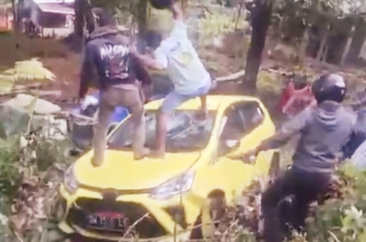 Tangkapan Layar Warga Memukul Kaca Depan Mobil yang Dikendarai AT Menggunakan Helem di Lingkungan Facei. (Rakyatmu)