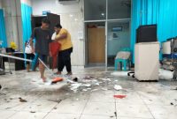 Petugas Kebersihan RSUD Chasan Boesoirie Ternate Membersihkan Ruangan dalam IGD yang Tergenang Air Hujan. (Rakyatmu)