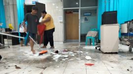 Petugas Kebersihan RSUD Chasan Boesoirie Ternate Membersihkan Ruangan dalam IGD yang Tergenang Air Hujan. (Rakyatmu)