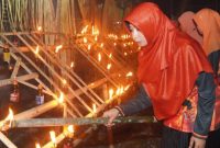 Istri Bupati Halmahera Selatan Bassam Kasuba, Rifa’at Al Sa’adah saat membakar obor dalam acara KKIG pada malam lailatul qadar. (Rakyatmu)