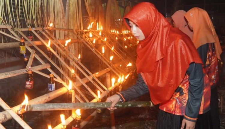 Istri Bupati Halmahera Selatan Bassam Kasuba, Rifa’at Al Sa’adah saat membakar obor dalam acara KKIG pada malam lailatul qadar. (Rakyatmu)