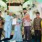 Bassam Kasuba menyerahkan sertifikat nikah kepada warga yang usai melakukan ijab kabul (Dok. Humas/Rakyatmu)