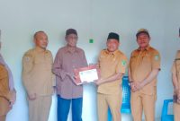 Sekretaris Daerah Kabupaten Kepulauan Sula Muhlis Soamole Menyerahkan Kado dari Bupati Fifian Adeningsih Mus Berupa Umroh dan Naik Haji kepada Salah Satu Tokoh Pemekaran Adam Mayau. (Rakyatmu)