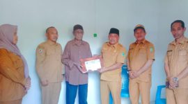 Sekretaris Daerah Kabupaten Kepulauan Sula Muhlis Soamole Menyerahkan Kado dari Bupati Fifian Adeningsih Mus Berupa Umroh dan Naik Haji kepada Salah Satu Tokoh Pemekaran Adam Mayau. (Rakyatmu)