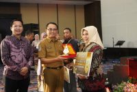 Plt. Sekprov Maluku Utara Abubakar Abdullah Serahkan Penghargaan ke Asisten Pemerintah dan Kesejahteraan Rakyat Setda Kota Ternate, Rukmini A. Rahman. (Rakyatmu)
