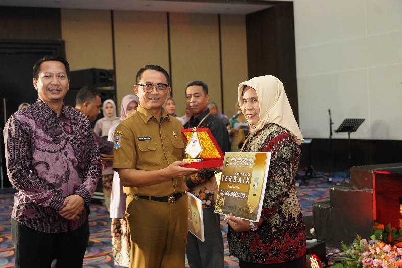 Plt. Sekprov Maluku Utara Abubakar Abdullah Serahkan Penghargaan ke Asisten Pemerintah dan Kesejahteraan Rakyat Setda Kota Ternate, Rukmini A. Rahman. (Rakyatmu)