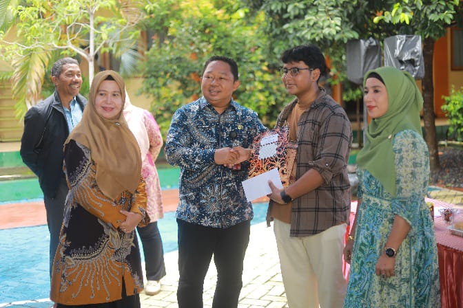 Ketua Komite Dr. Rizal Marsaoly Menyerahkan Rapot Siswa SMA 8 Kota Ternate. (Rakyatmu)