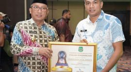 Wali Kota Ternate, M. Tauhid Soleman Didampingi Plt. Kepala Disnaker Faizal Baddarudin saat Menerima Penghargaan Peringkat 1 Paritrana Award 2025. (Humas for Rakyatmu)