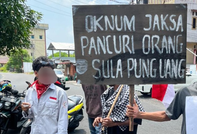 Umbul-umbul Massa Aksi Tertulis 'Oknum Jaksa Pancuri Orang Sula Pung Uang' Kasus Korupsi BTT Kepulauan Sula. (RakyatMu)