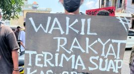 Umbul-umbul massa aksi saat unjuk rasa terkait kasus korupsi BTT Kepulauan Sula di depan Pengadilan Negeri Ternate pada 13 Oktober 2025. (Rakyatmu)