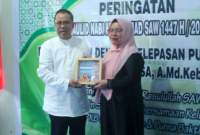 Penyerahan Cendramata dari Kepala Dinas PPKB Kota Ternate kepada Rusni Salasa saat Purna Bakti