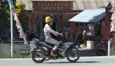 Seorang pekerja mengenakan masker melintas di depan Puskesmas Lelilef, Weda Tengah, Halmahera Tengah. Foto: Nurkholis Lamaau