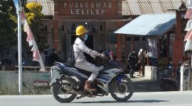 Seorang pekerja mengenakan masker melintas di depan Puskesmas Lelilef, Weda Tengah, Halmahera Tengah. Foto: Nurkholis Lamaau