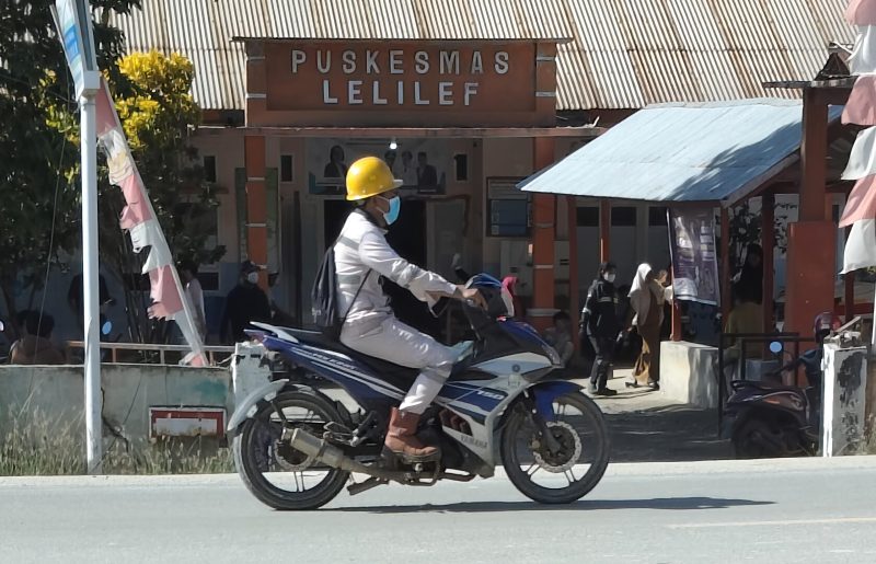 Seorang pekerja mengenakan masker melintas di depan Puskesmas Lelilef, Weda Tengah, Halmahera Tengah. Foto: Nurkholis Lamaau