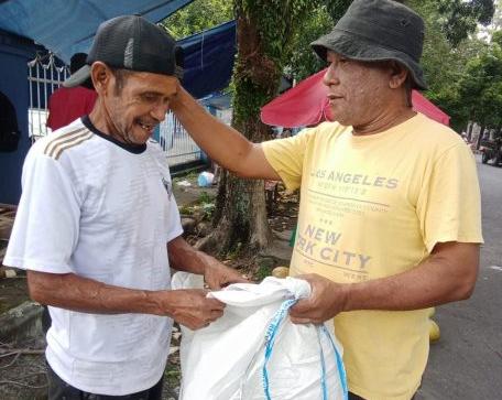 Salah satu Prtugas DLH Kota Ternate saat Beri Karung Secara Gratis ke Pedagang Kelapa Buah